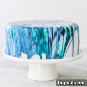 Blue tie-dye frosting dripping from the side of cake