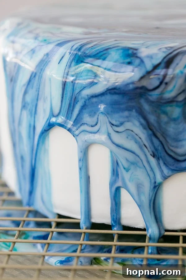 A close-up shot of the side of a marble drip cake, clearly showing the intricate and artistic patterns of the marbled icing.