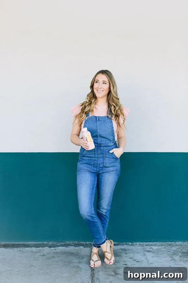 Eden Passante against a wall, holding moon juice 