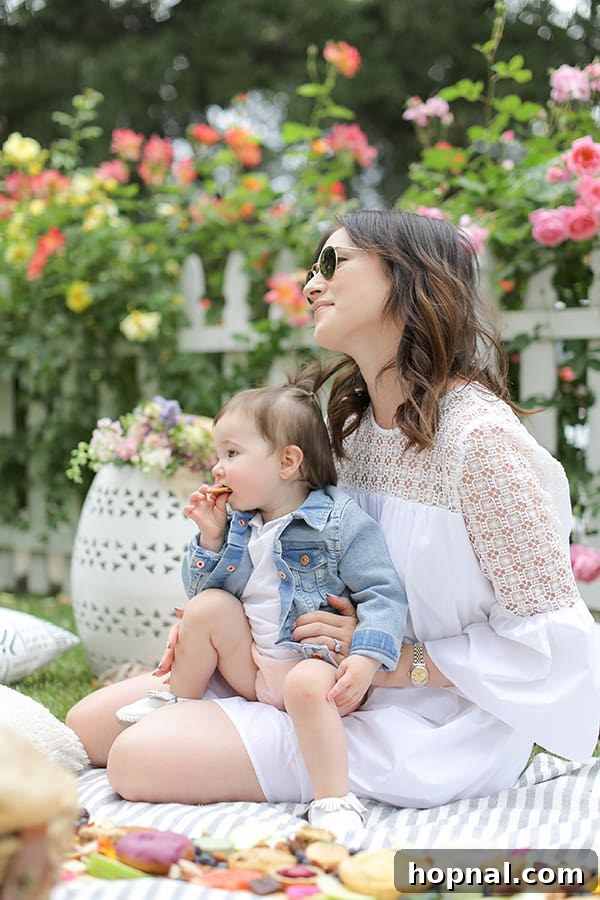 A loving woman gently holding her toddler at a cheerful Mother's Day picnic, capturing a precious family moment amidst the celebration.