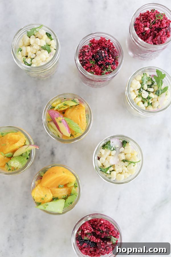 Individual vegetable salads perfectly layered in mason jars, showcasing fresh ingredients and vibrant colors, ready for a healthy picnic meal.