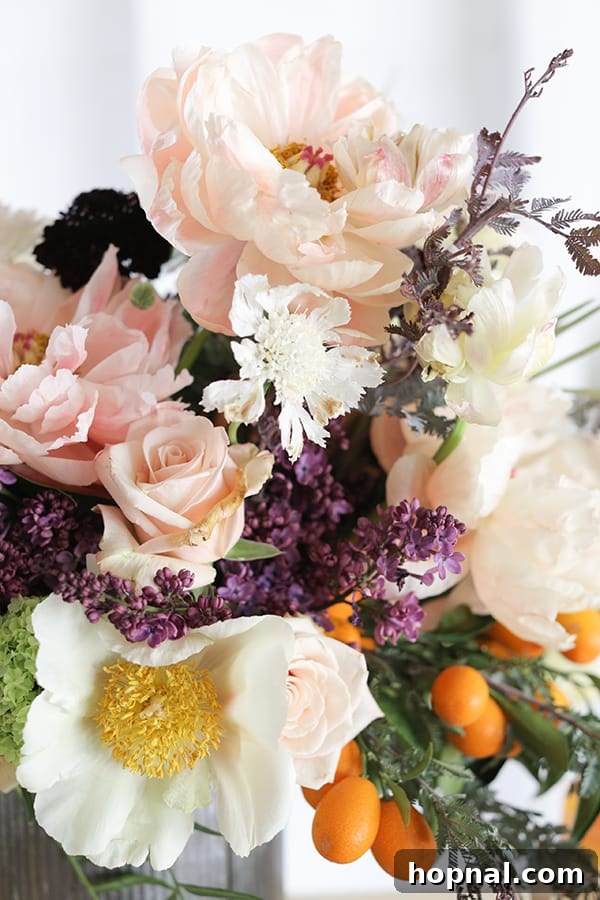 Boozy Greyhound Pops 5 Pink flowers with kumquats as a garnish, illustrating decorative elements.
