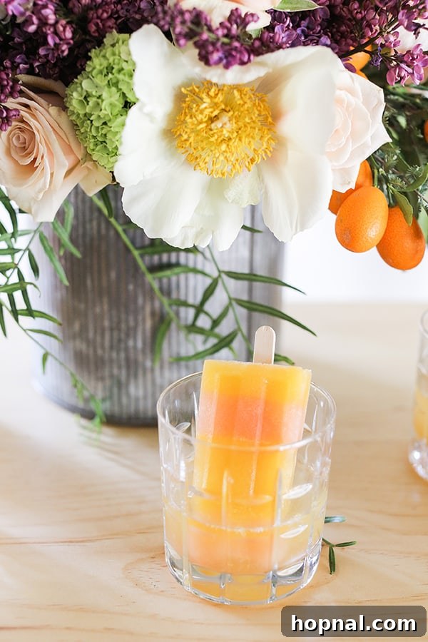 Boozy Greyhound Pops 8 Striped popsicles in a glass, ready for a refreshing moment.