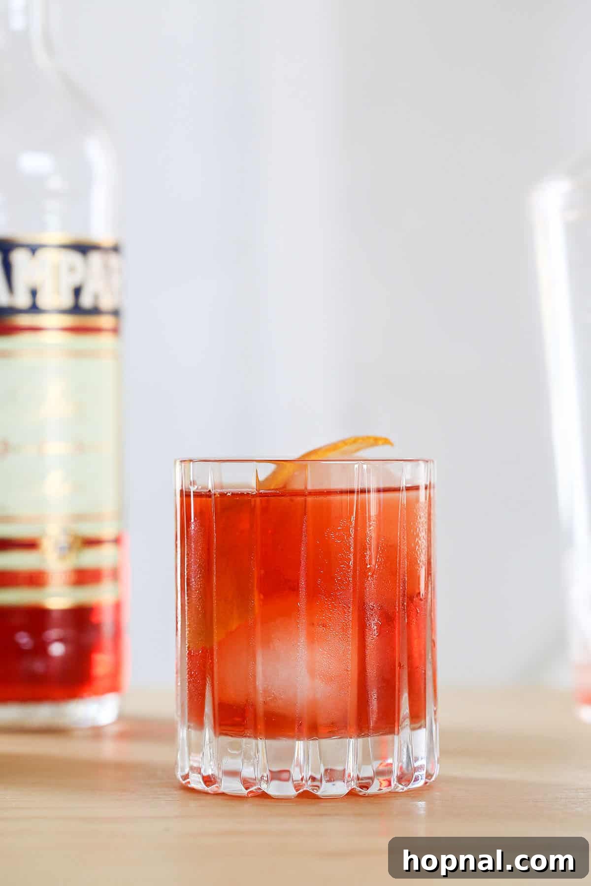 Negroni cocktail recipe made with Campari, gin, and sweet vermouth, garnished with an orange slice.