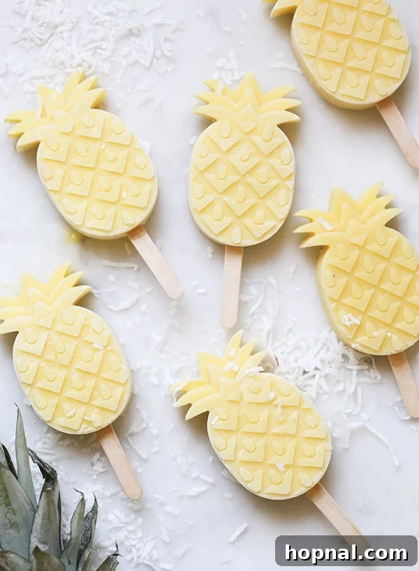 Top down shot of several pineapple-shaped popsicles with a tropical aesthetic