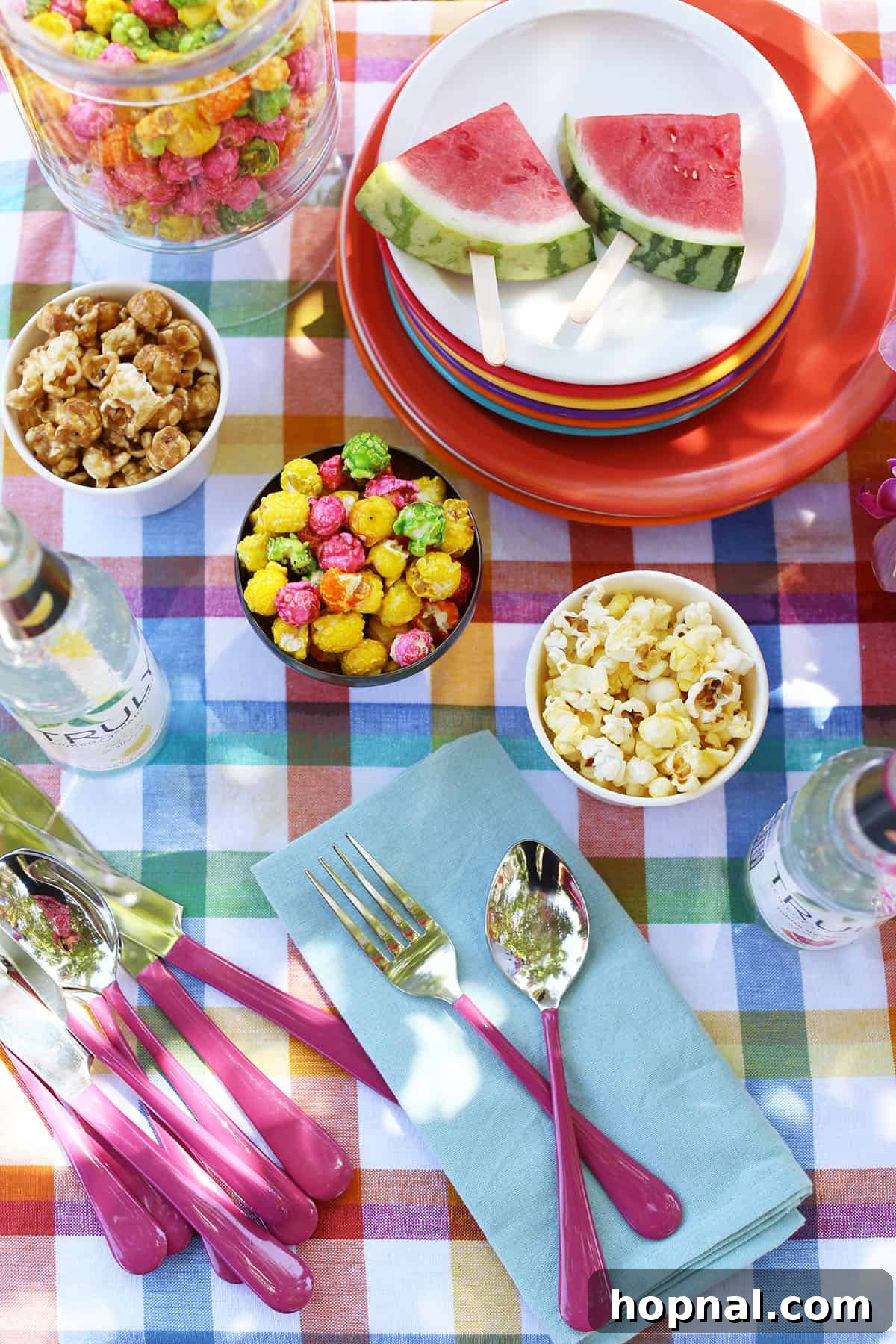 Backyard Big Top Bash 10 Essential carnival party supplies laid out, including a popcorn maker and colorful cups