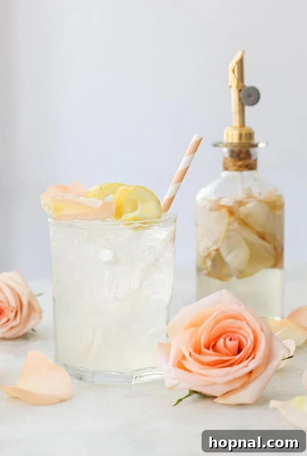 Petal Potion 5 Rose Water Cocktail with a single fresh rose bloom and a slice of lemon garnish.