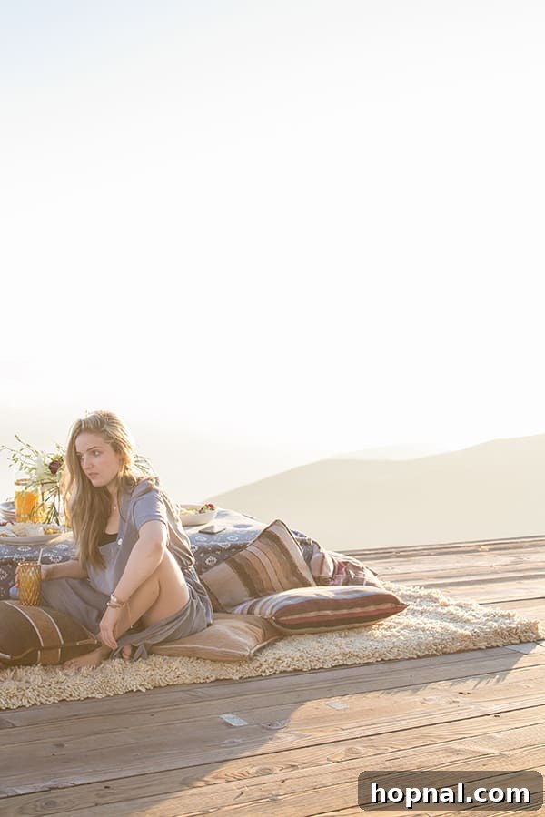 The Art of Airstream Entertaining in Malibu 15 The dramatic landscape of Malibu with someone seemingly hanging on a cliff, emphasizing the exhilarating and adventurous aspect of the location.