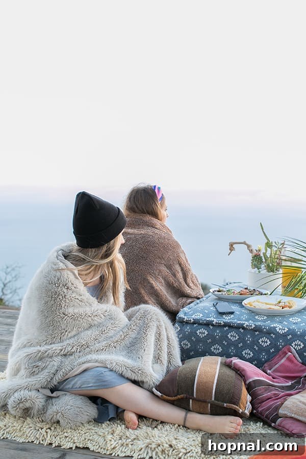 The Art of Airstream Entertaining in Malibu 20 Girls wrapped in cozy blankets on a deck, enjoying stargazing and conversation during their comfortable glamping experience in Malibu.
