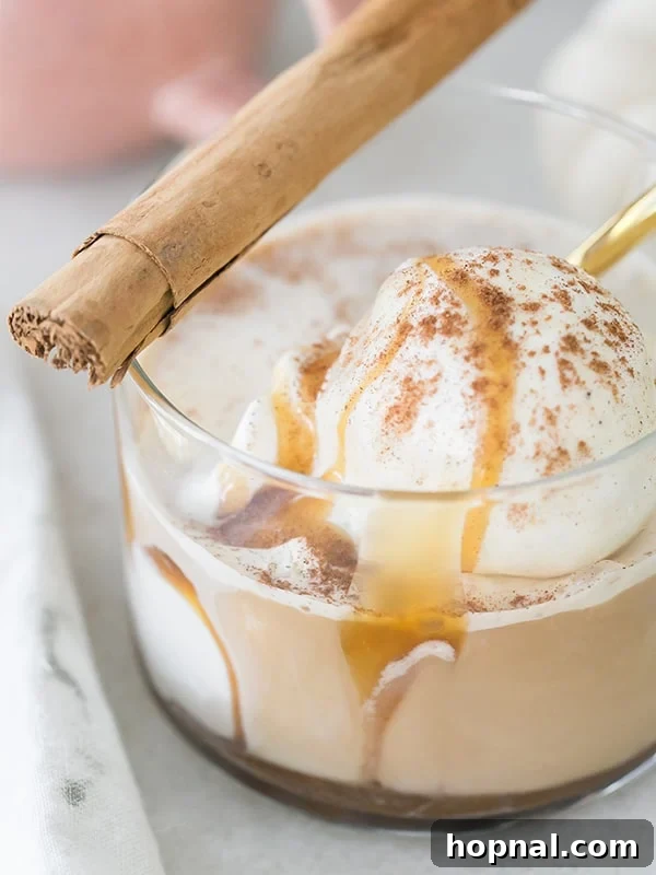 Autumn Spiced Affogato Dream 2 Creamy vanilla ice cream in a clear glass with dark coffee being poured over, topped with a cinnamon stick, against a backdrop of fall decor.