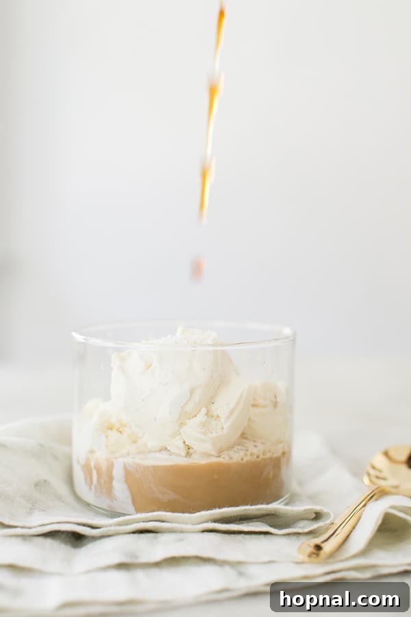 Autumn Spiced Affogato Dream 4 Hot coffee being poured over a scoop of vanilla ice cream in a glass, ready for toppings.