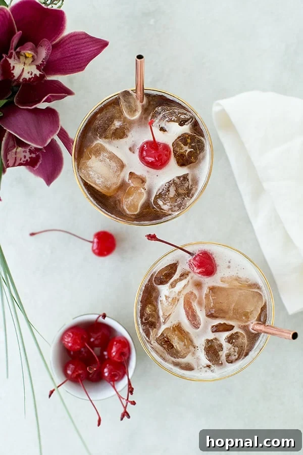 A coffee tonic recipe with a cherry, elegantly displayed on a marble table.