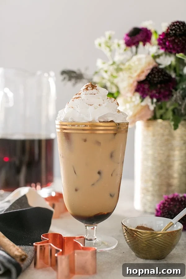 Spiced Gingerbread Cold Brew Latte 2 Gingerbread Cold Brew Latté with whipped cream on a table with flowers.