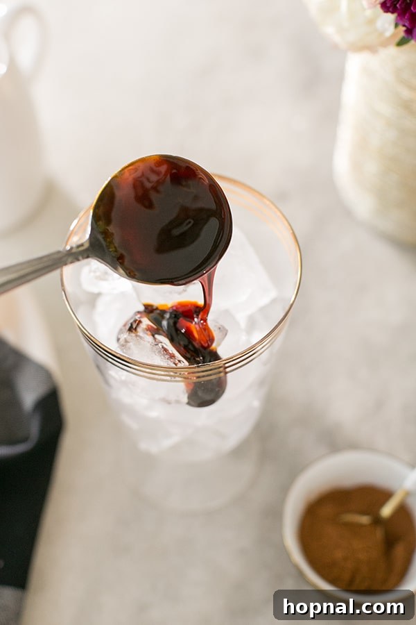 Spiced Gingerbread Cold Brew Latte 3 Molasses dripping in glass filled with ice.