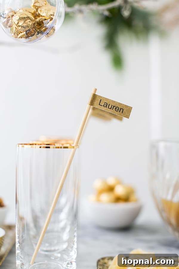 A personalized drink stirrer, crafted with gold patterned tape and a bamboo skewer, placed in a festive cocktail glass
