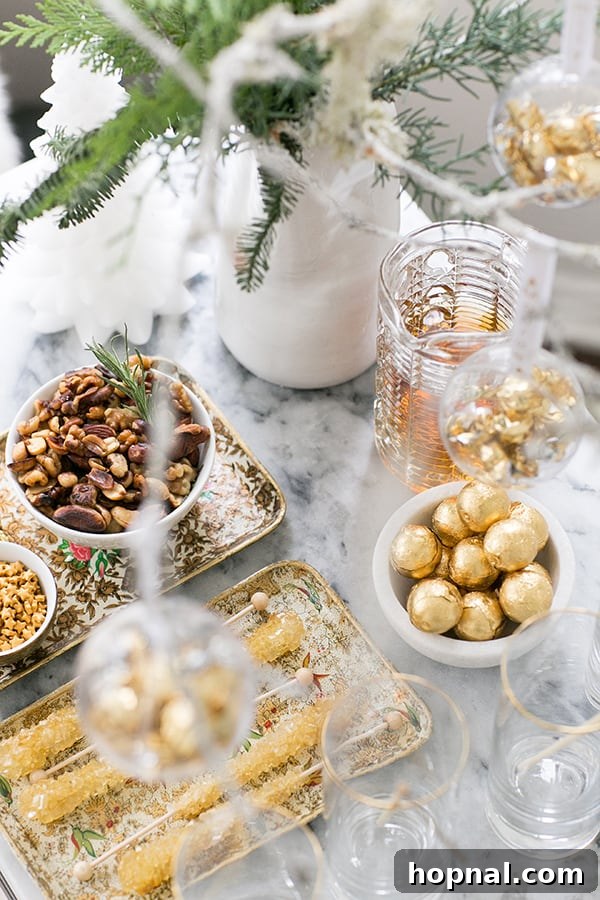 Overhead shot of a full holiday drink station setup, showcasing an array of cocktails, small bites, and elegant decorative elements