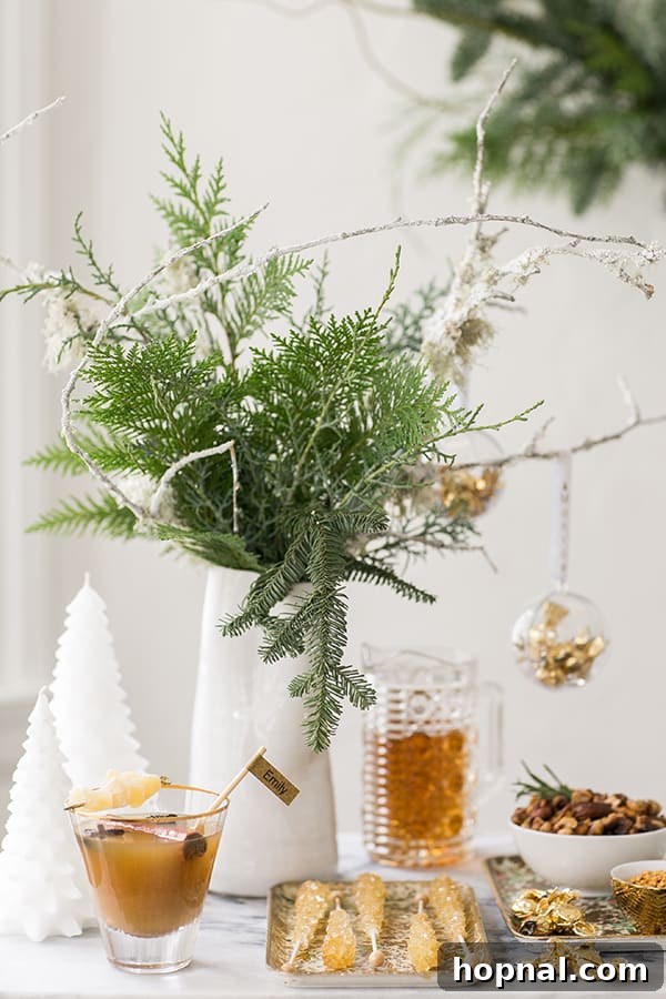A glass vase filled with fresh green foliage, serving as a simple yet effective decorative accent on the holiday drinks table