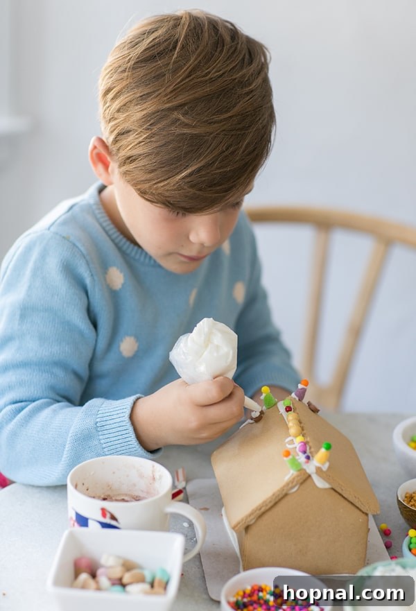 Your Ultimate Guide to an Epic Gingerbread House Decorating Party 6 romeo decorating a gingerbread house - graham crackers, winter wonderland