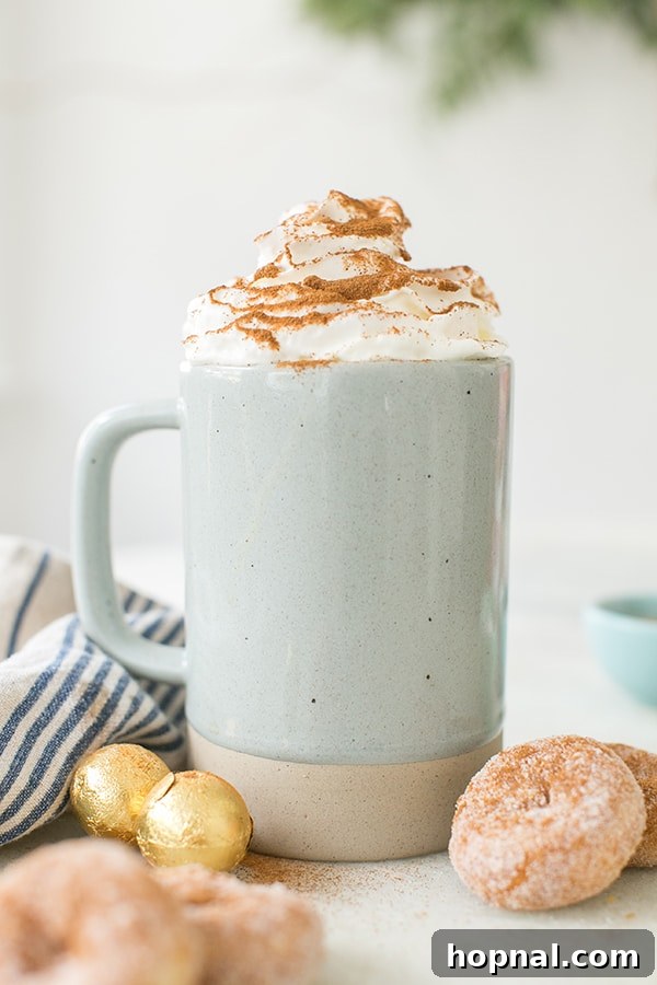 A vibrant blue mug filled with a frothy coffee drink, topped generously with whipped cream, sits on a wooden surface.