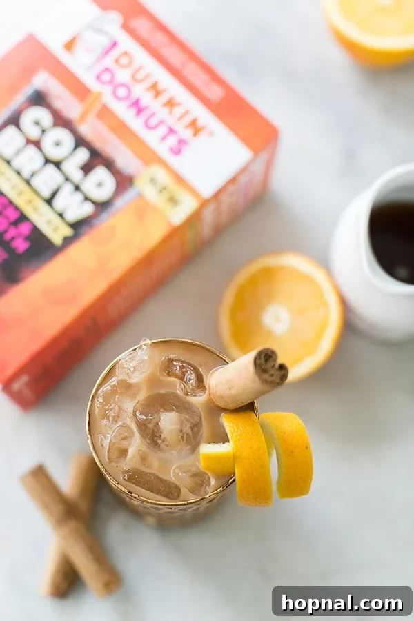 Dunkin' Donuts Cold Brew Coffee brewed in a glass with a cinnamon stick and orange rind. 