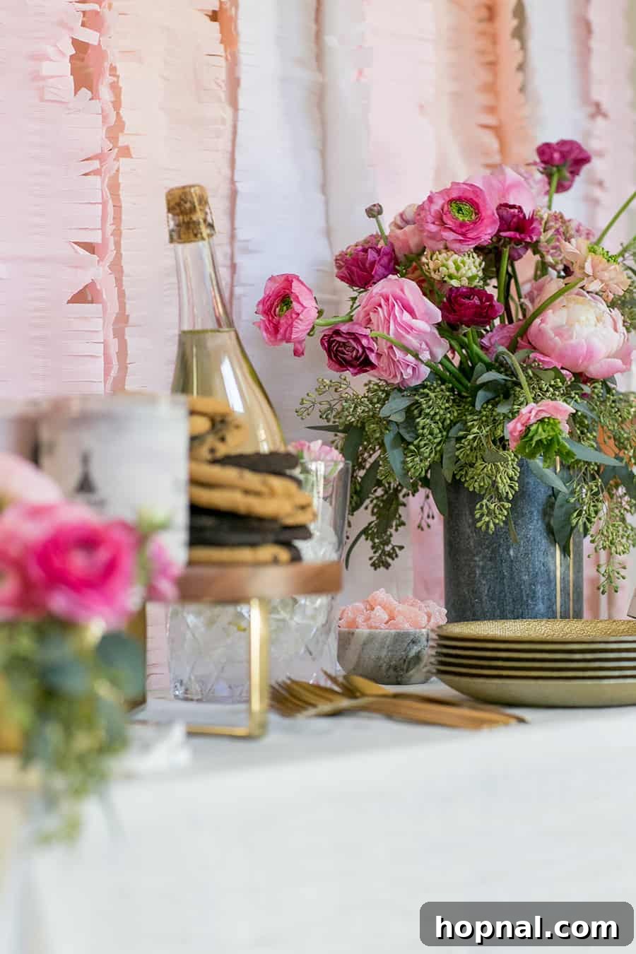 A beautifully decorated Valentine's Day bar, featuring an array of fresh flowers, heart-shaped cookies, elegant plates, and sparkling wine, ready for a festive celebration.