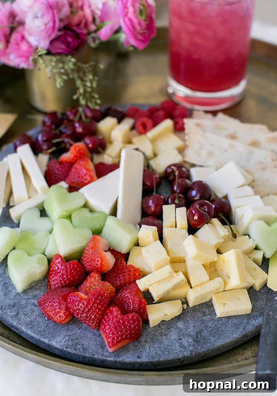 A festive Galentine's Day cheese platter showcasing an assortment of cheeses and fruits, thoughtfully cut into heart shapes, creating a loving presentation.