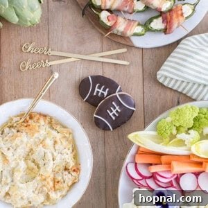 A close-up of cheesy baked artichoke dip served with vegetables and crackers