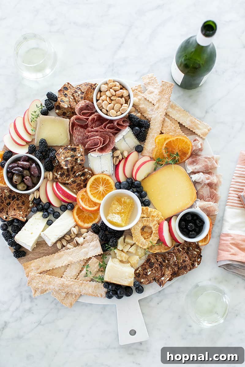 A bountiful ultimate cheese platter, artfully arranged with various cheeses, meats, fruits, and crackers.