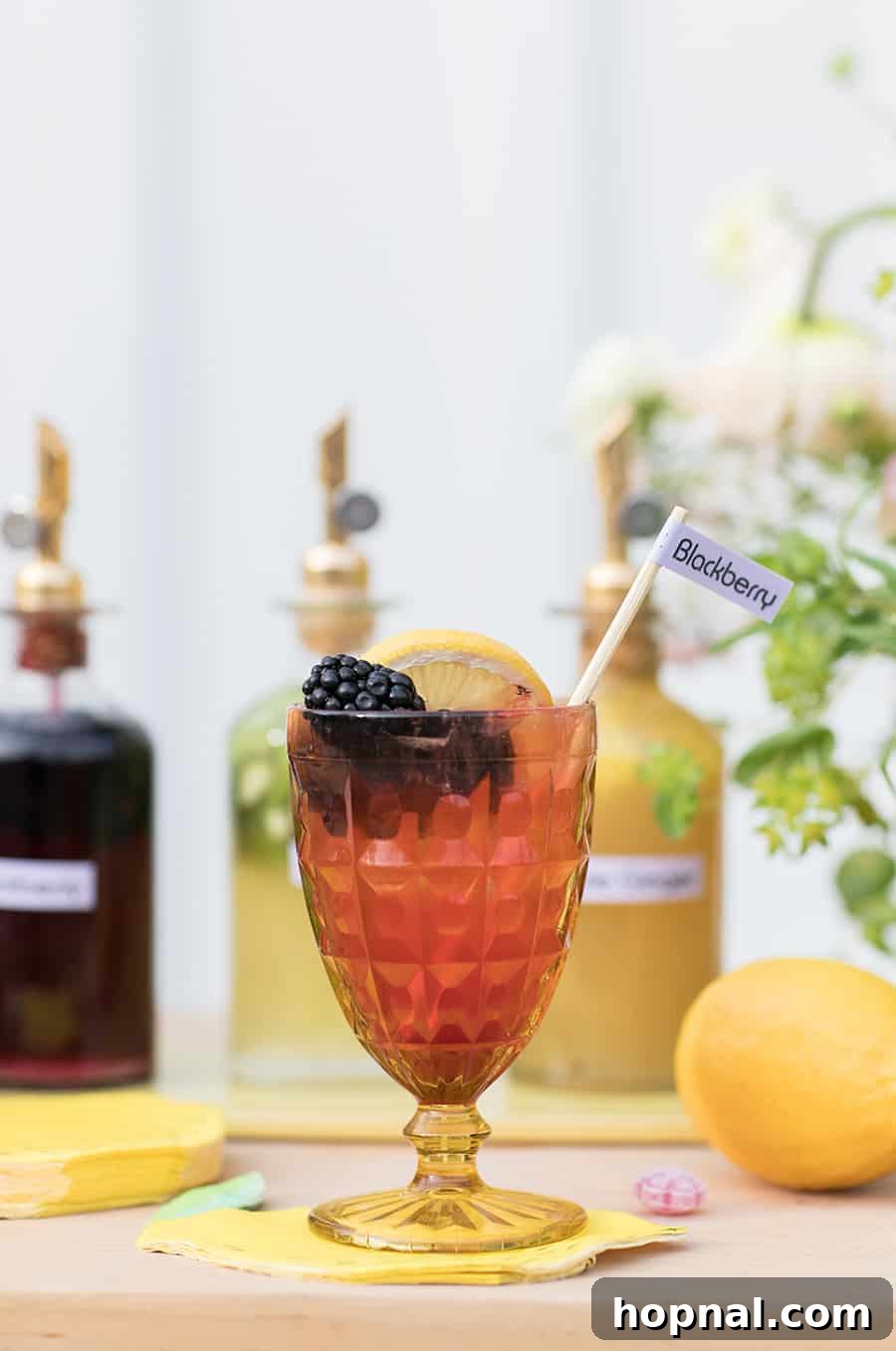 Three vintage yellow glasses filled with sparkling spiked lemonade, garnished with fresh lemon slices, set against a light background, ready to be enjoyed.