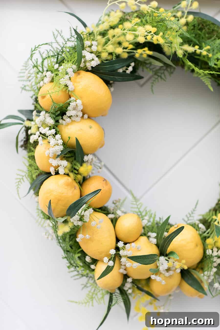 Artfully arranged fresh lemons nestled within a verdant decorative wreath, enhancing the bright citrus theme and inviting atmosphere.