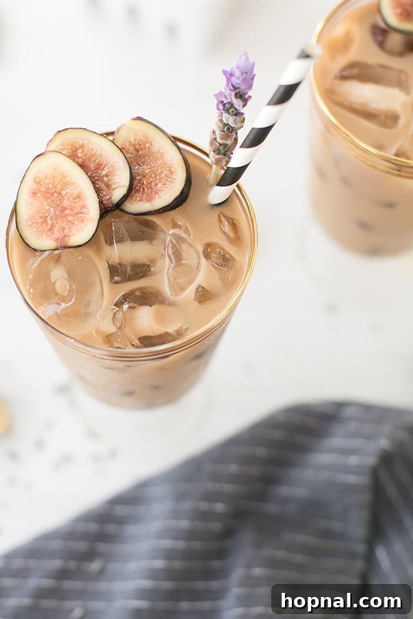 Close-up of a finished Fig and Lavender Cold Brew Coffee in a glass, garnished with a fresh fig slice and lavender sprig, ready to be enjoyed.
