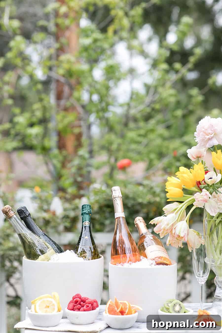 Bottles of Champagne over ice with bowls of fruit.