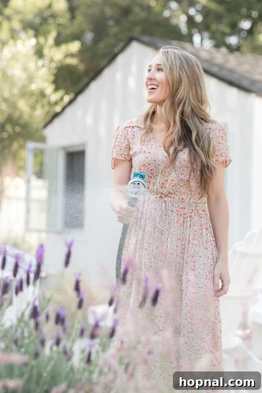 Eden Passante gently watering her lush tea garden, showcasing healthy herbs and plants thriving under care.