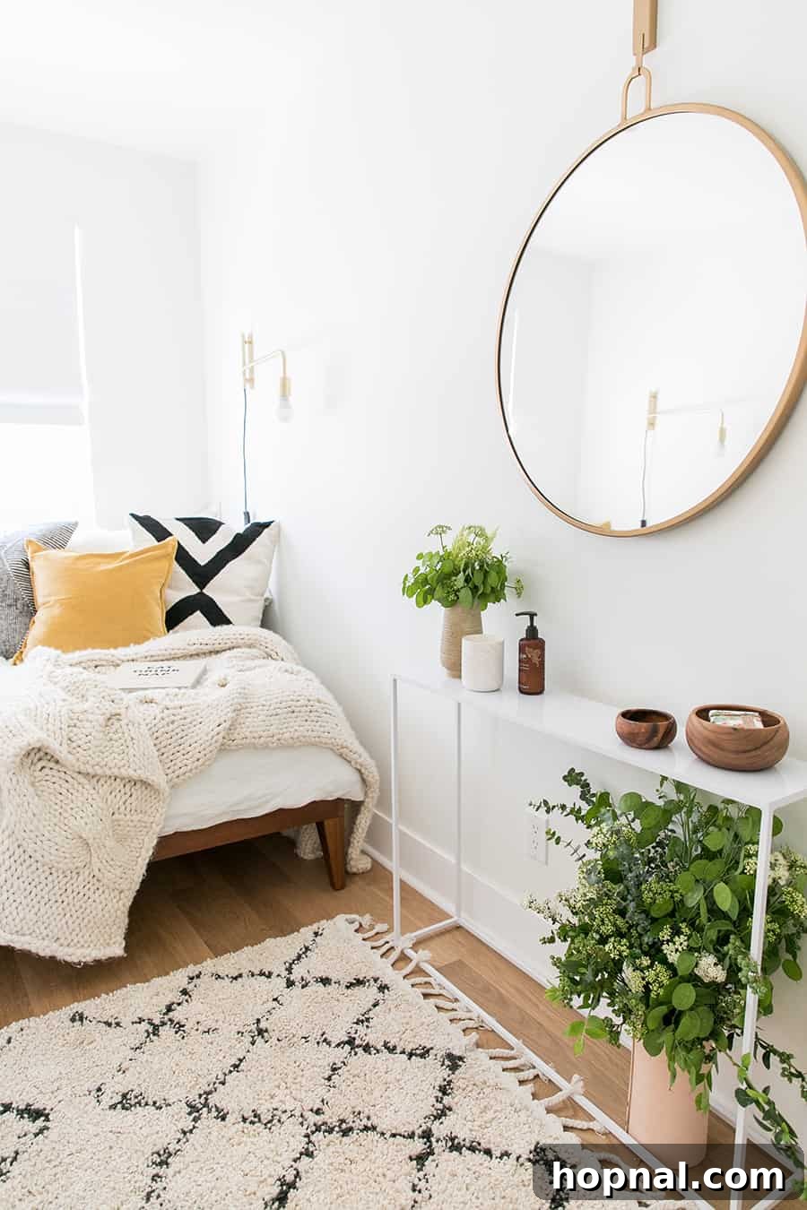 Designing a Welcoming Guest Room Oasis 13 A guest bedroom retreat with rug, mirror, flowers, bed, pillows.