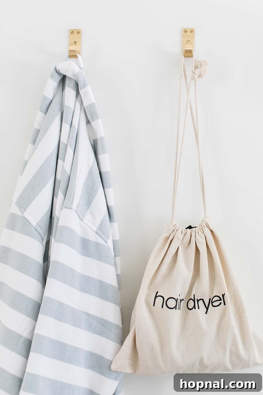 Designing a Welcoming Guest Room Oasis 8 hair dryer on a hook with a striped robe.