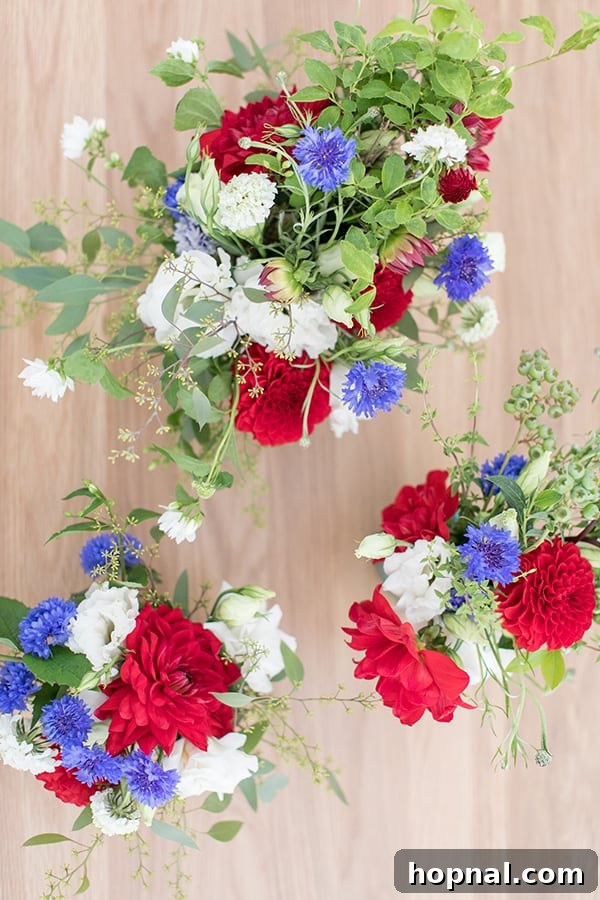 Finished 4th of July flowers with red, white, and blue blooms arranged on a rustic wood table.