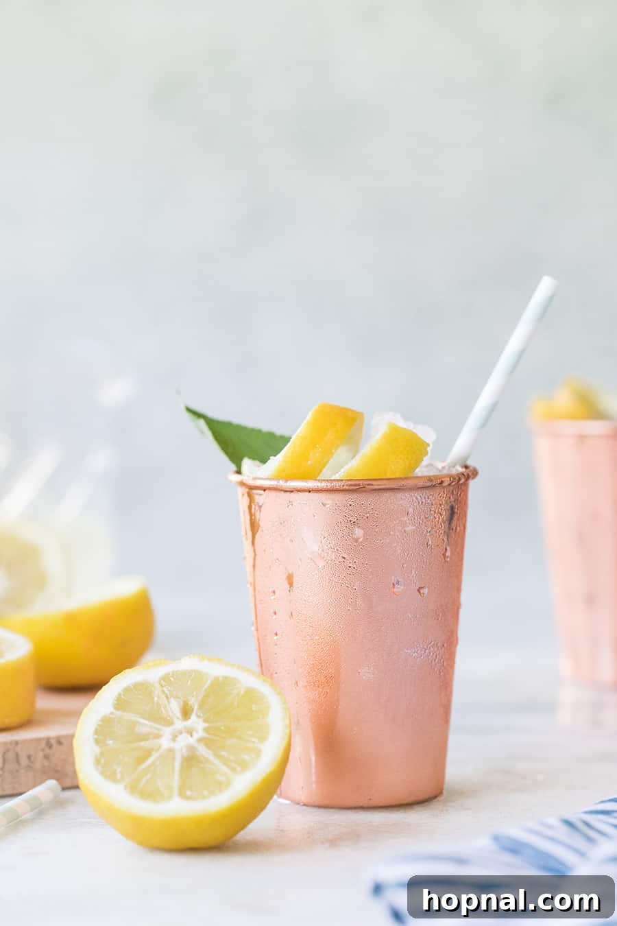 Refreshing Lemon and Sage Moscow Mule in a sleek copper tumbler, garnished with lemon and sage.