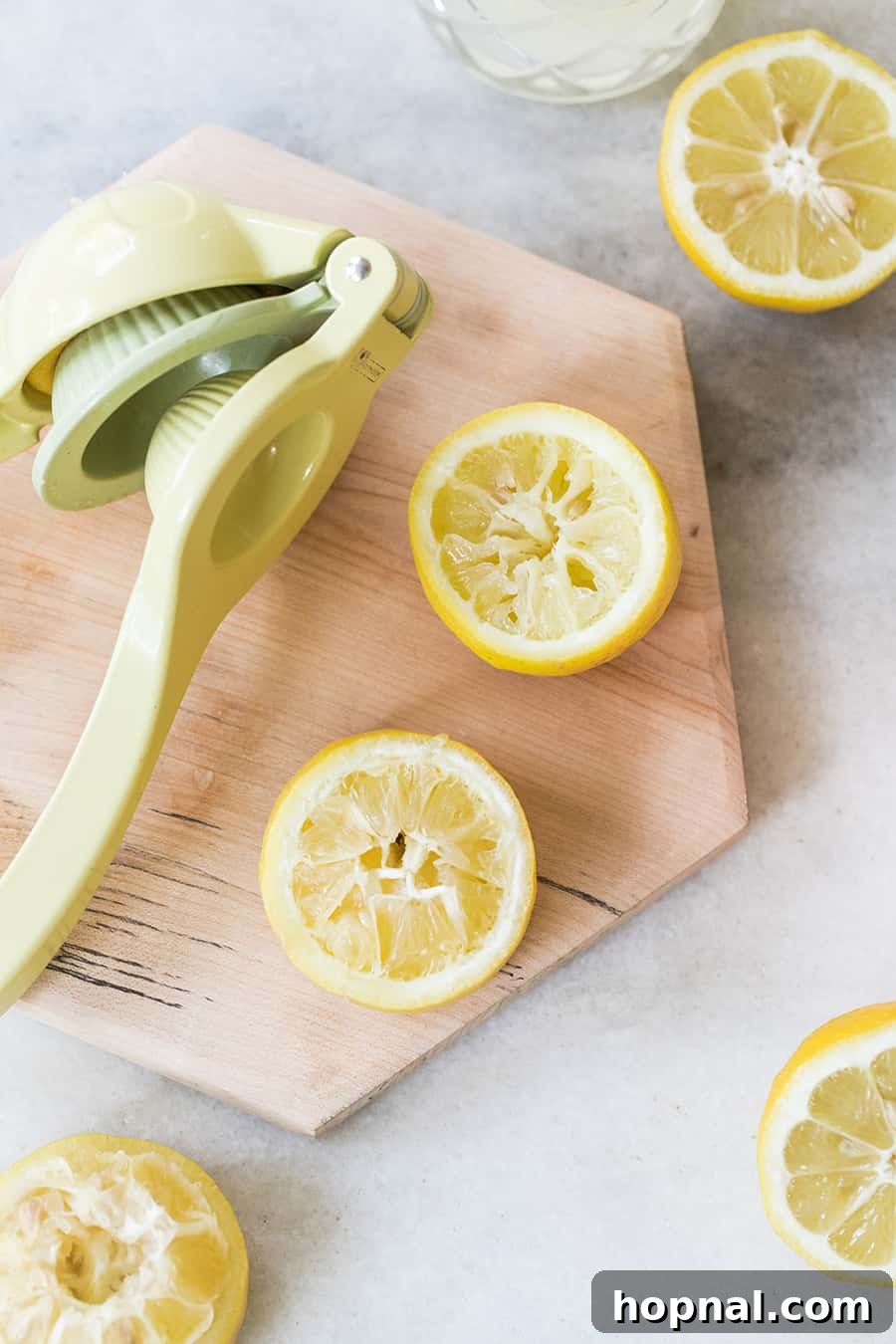 Fresh lemons and sage leaves artfully arranged on a wooden table, ingredients for a Moscow Mule.