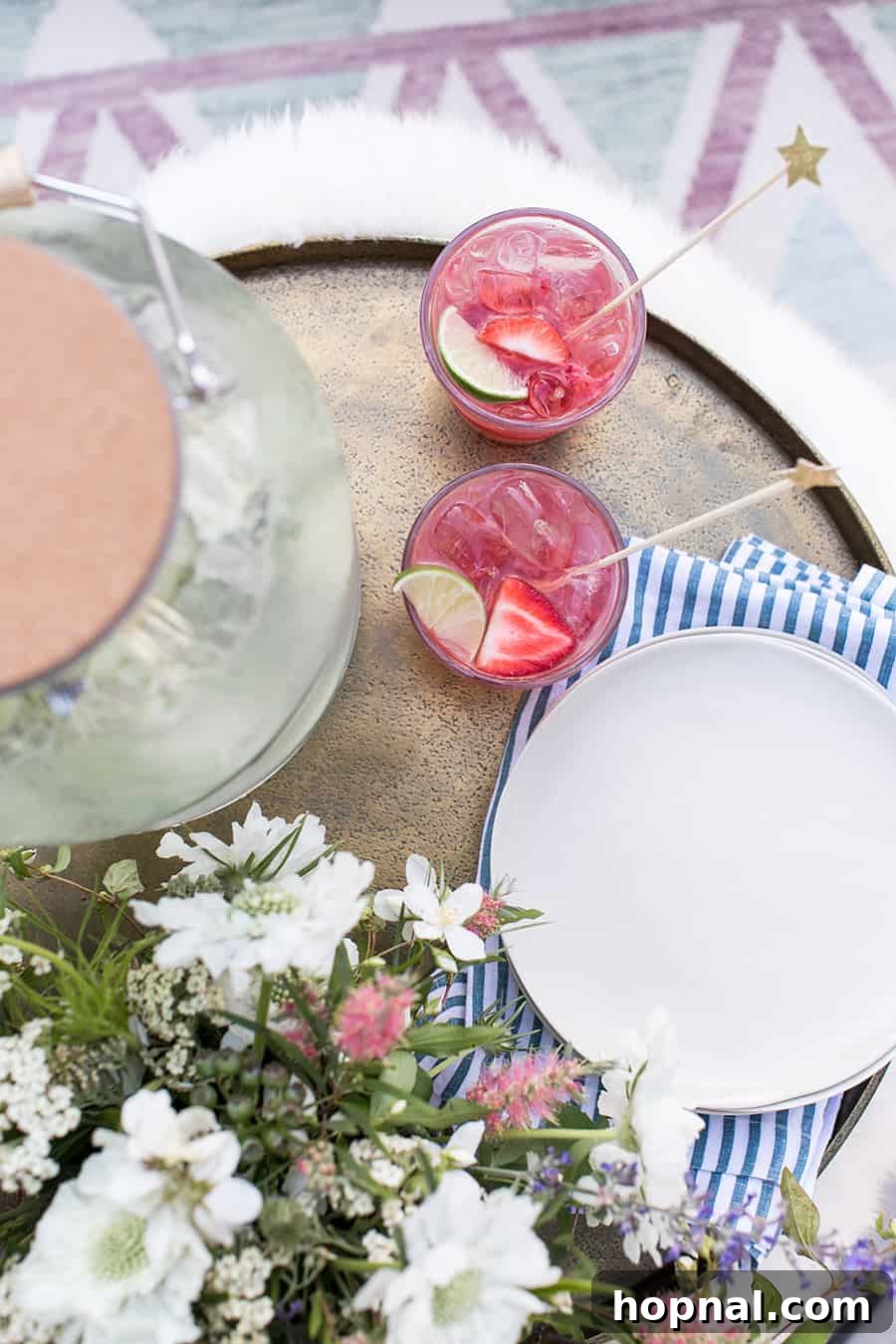 Lights, Camera, Backyard: Your Outdoor Movie Night Guide 19 An overhead view of two red cocktails with plates arranged on a stylish gold tray, perfect for an elegant outdoor gathering.