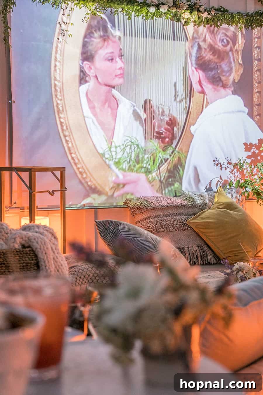 Lights, Camera, Backyard: Your Outdoor Movie Night Guide 20 An outdoor movie screen displaying a film, surrounded by comfortable pillows, creating a relaxed viewing environment.