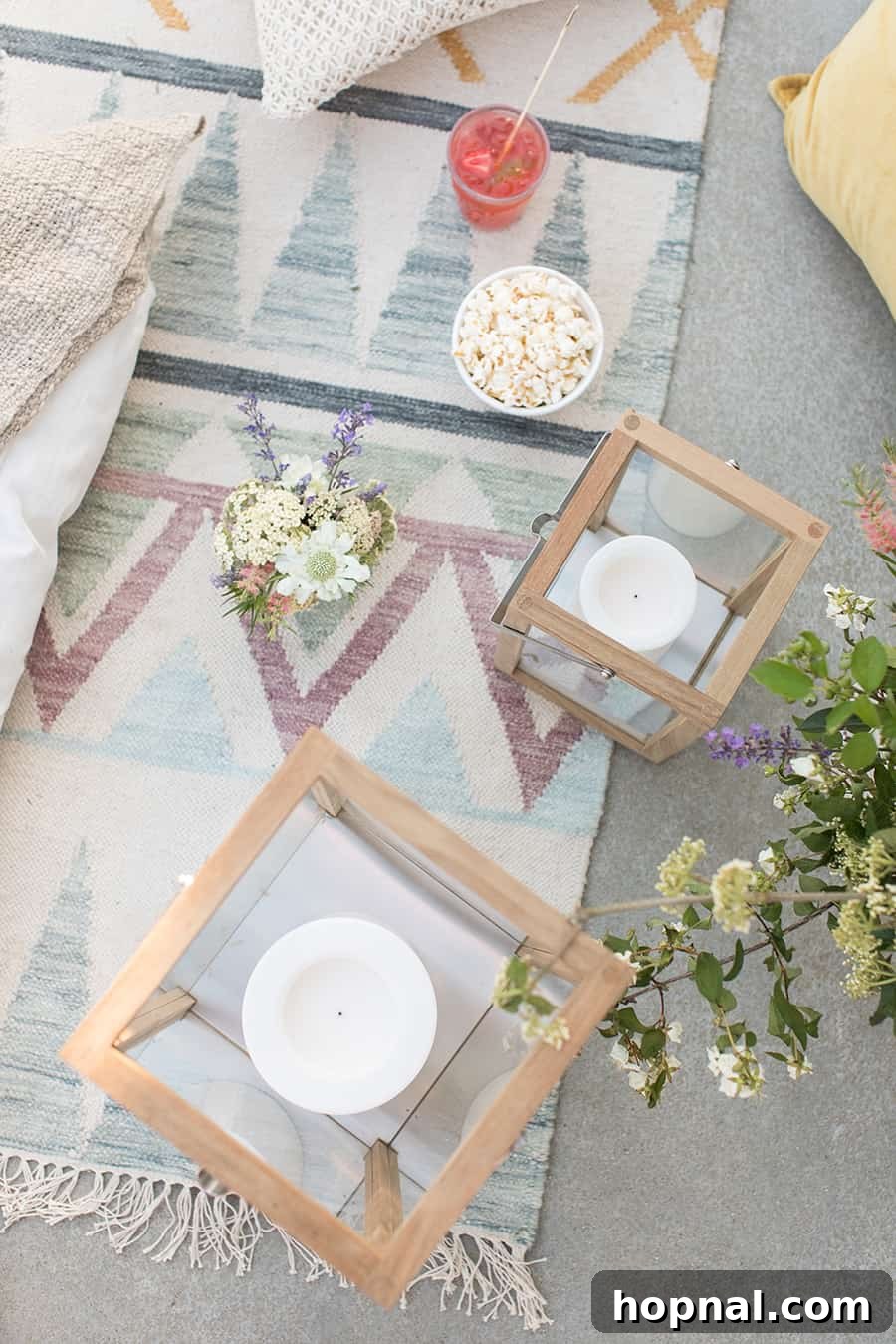 Lights, Camera, Backyard: Your Outdoor Movie Night Guide 7 An overhead shot showcasing teak lanterns with fresh flowers and a bowl of popcorn, creating a charming outdoor setting.