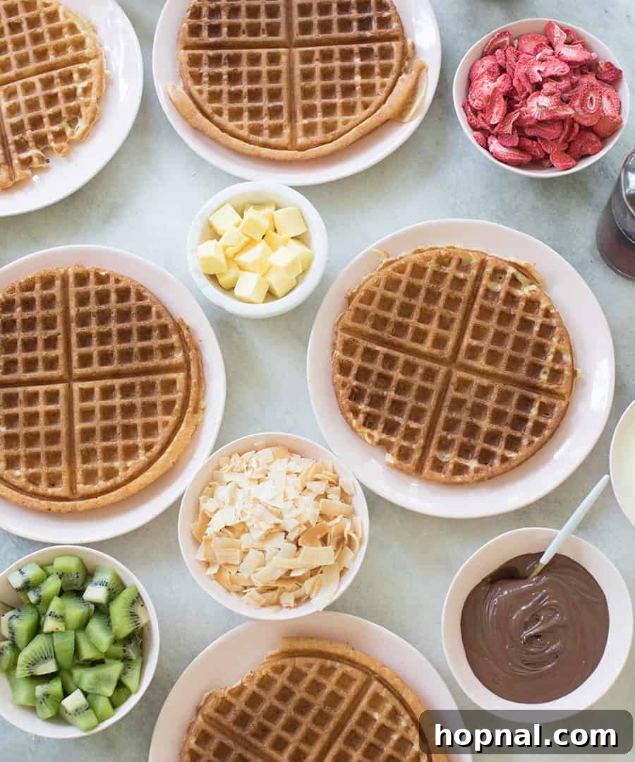homemade waffle recipe with butter, coconut, berries on a table.