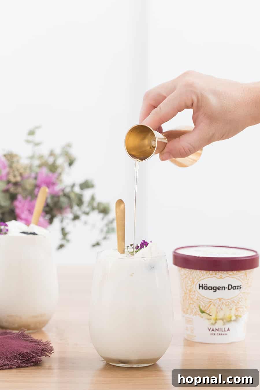 syrup being poured into a glass filled with ice cream 