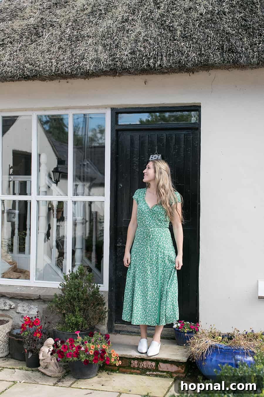 Master the Art of Irish Soda Bread 11 Eden Passante standing smiling outside the charming, traditional thatched-roof cottage in Northern Ireland.