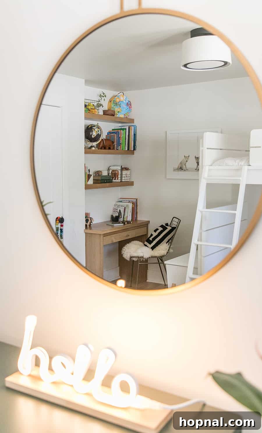 Gold mirror looking at a built in desk and bunk beds.
