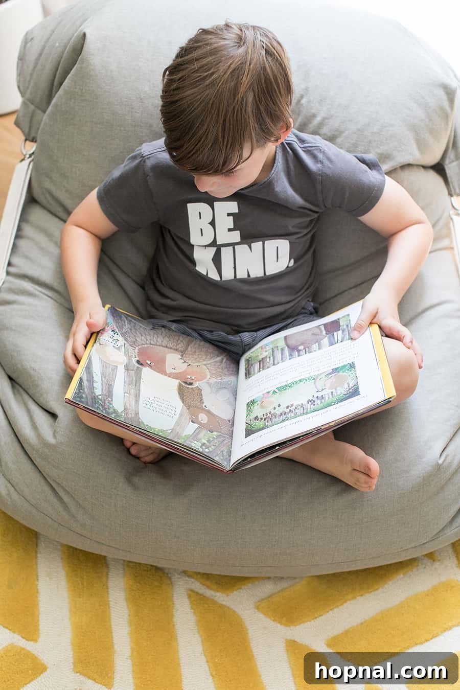 Little boy in a beanbag chair reading a book.
