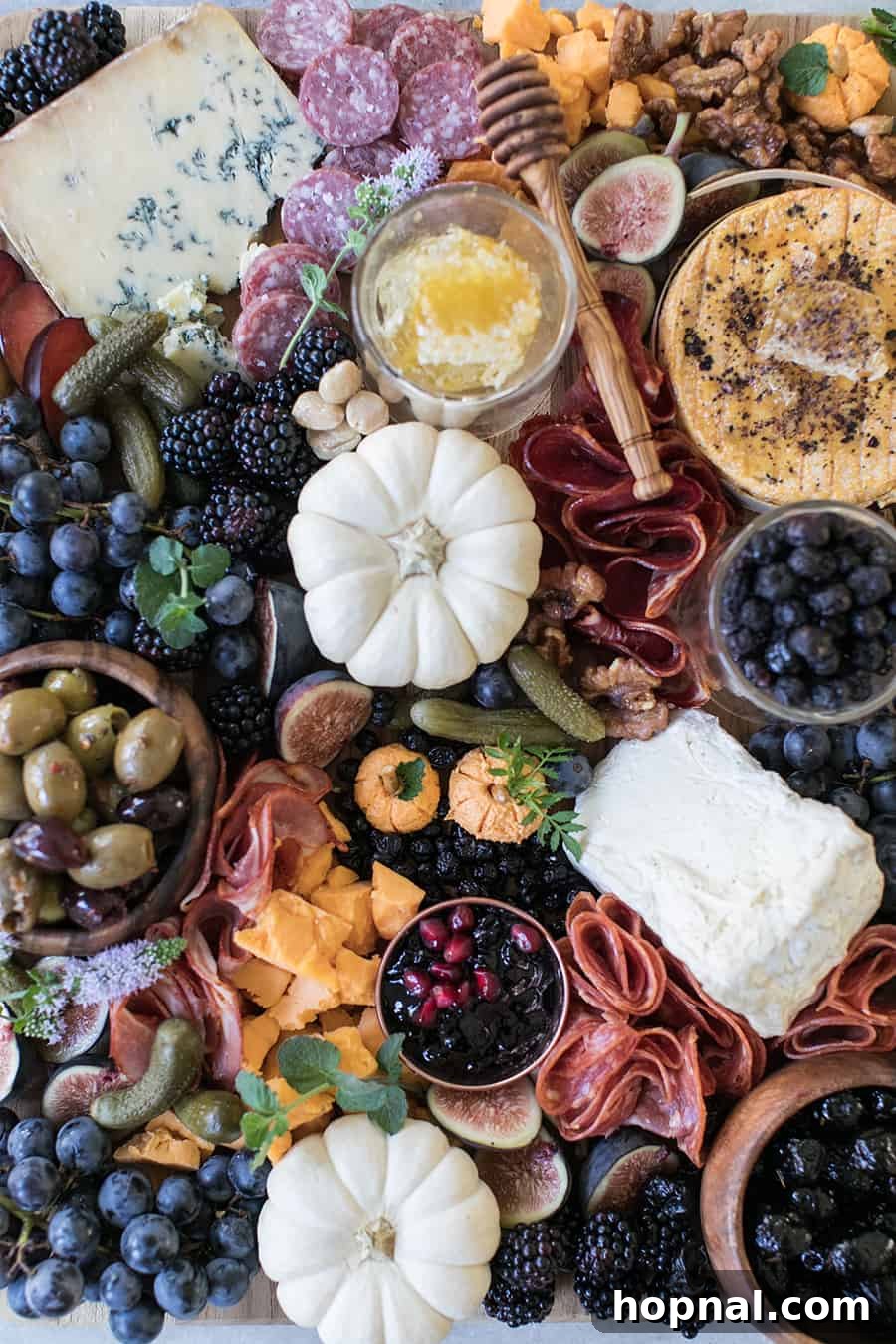 Halloween Meat and Cheese Board with pumpkins, berries, pickles, olives, cheese and meat, highlighting the homemade cheese pumpkins.