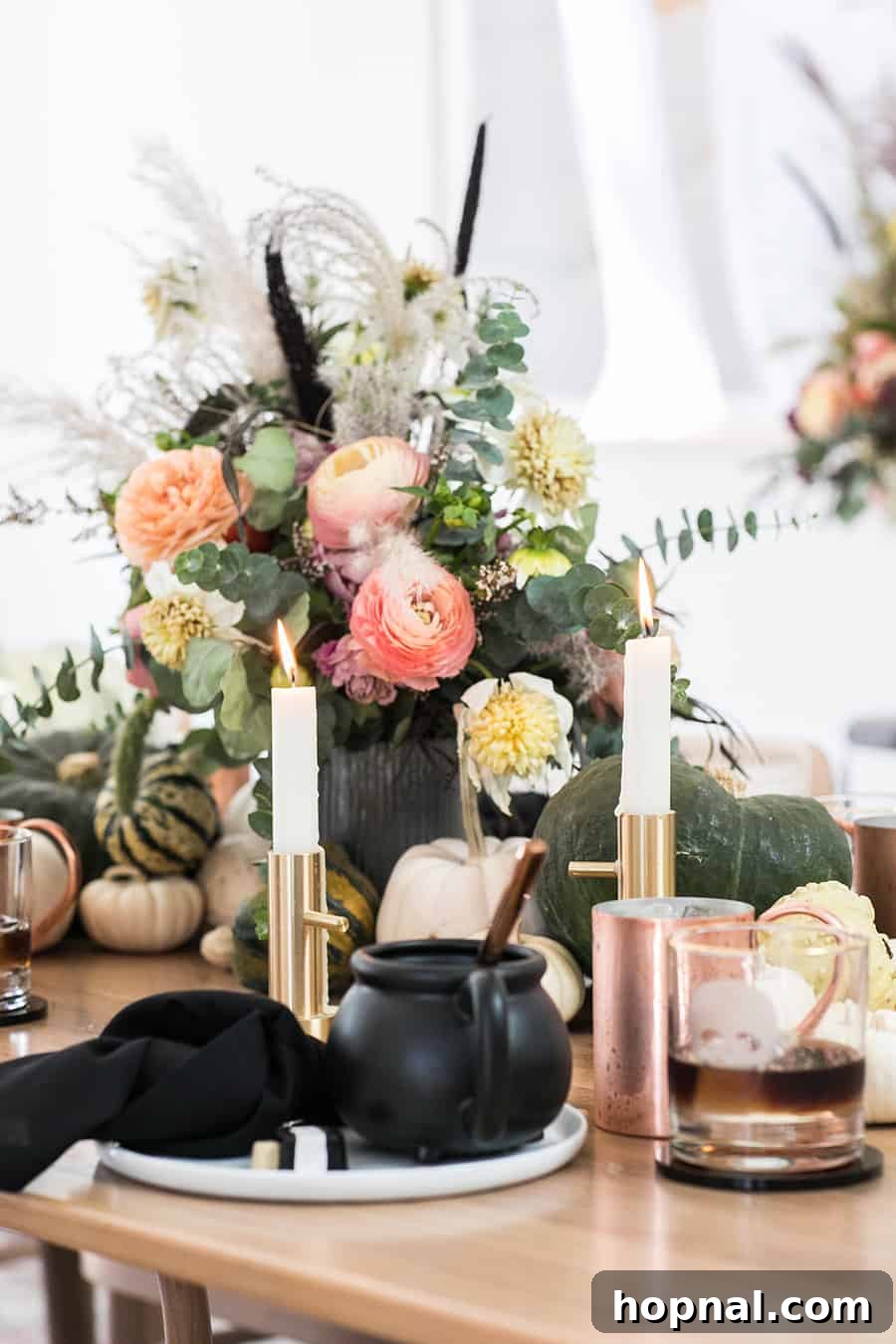Halloween dinner ideas tabletop with table with curried butternut squash soup on it, surrounded by fall decor and candles.