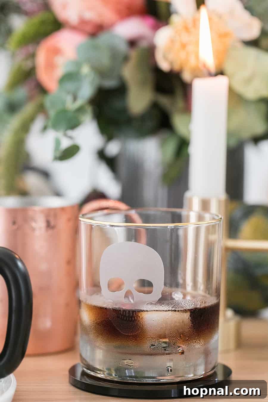 A sophisticated cocktail served in a skull-shaped glass, enhancing the elegant Halloween theme.