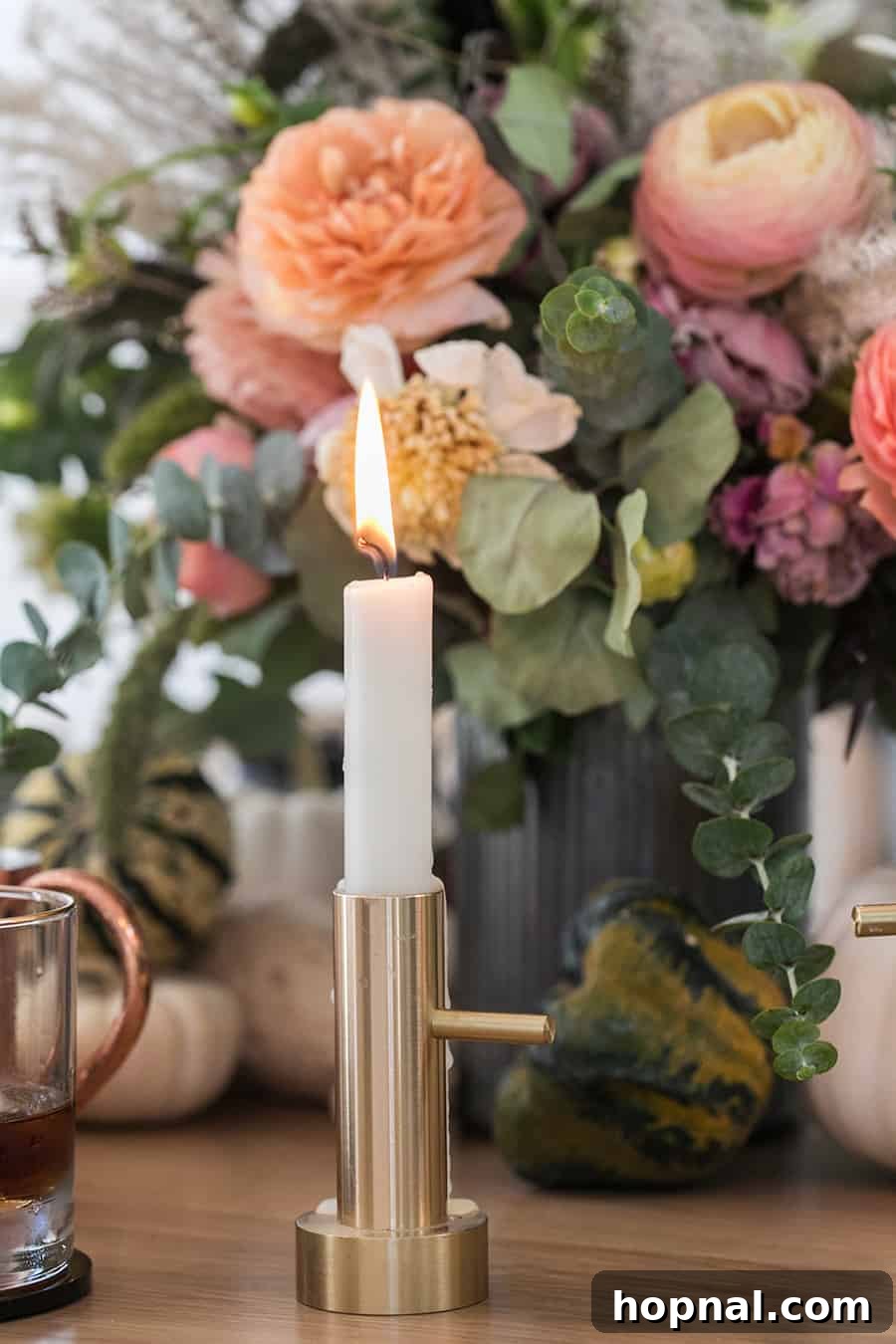 A lit brass candlestick adding a warm glow to a charmingly spooky Halloween table setting.